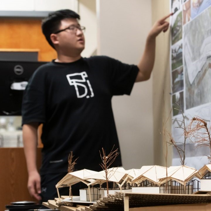 student pointing to building plans