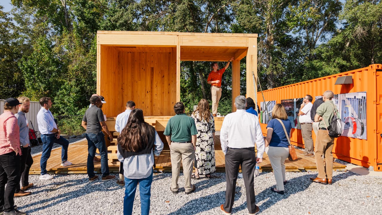 man showing a mass timber structure to an audience