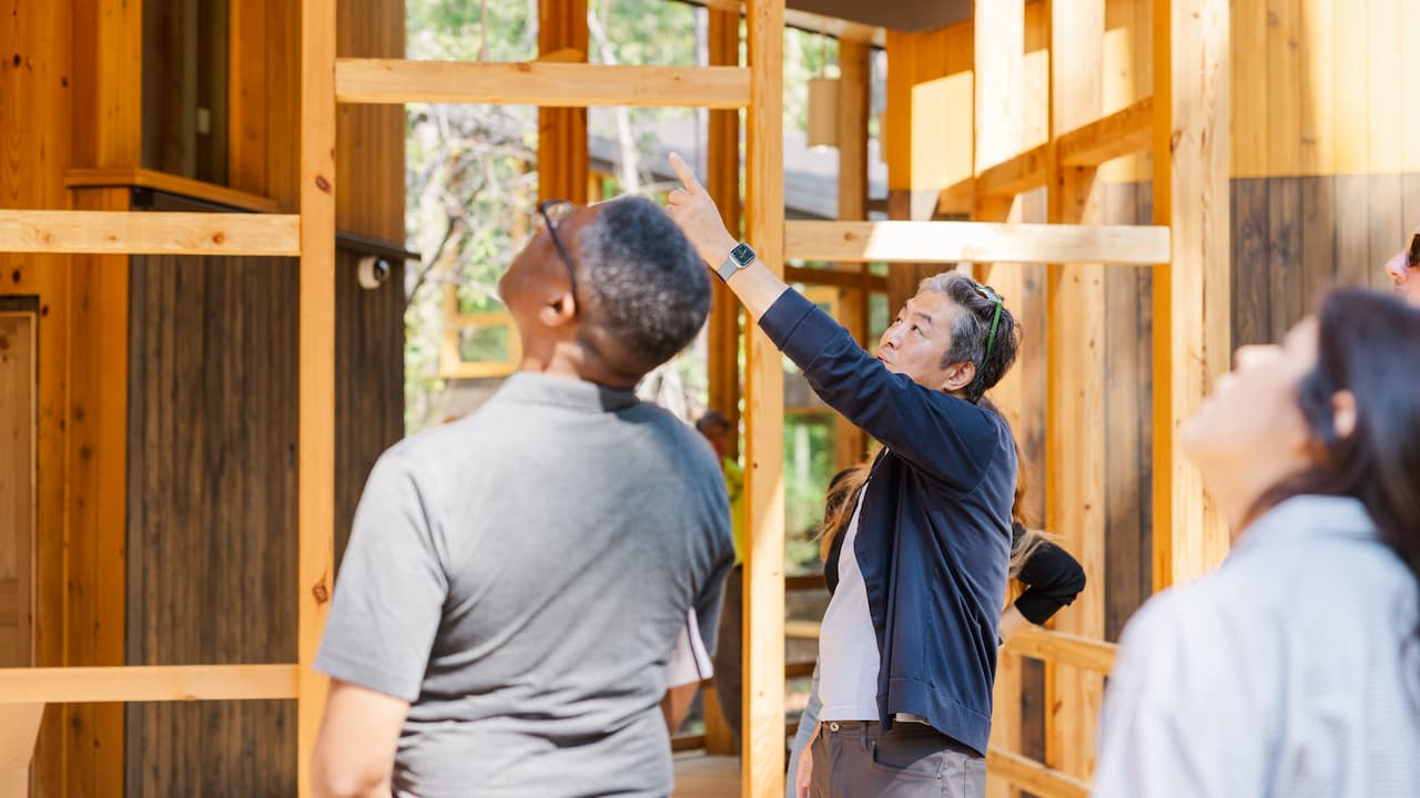 man pointing to a mass timber structure